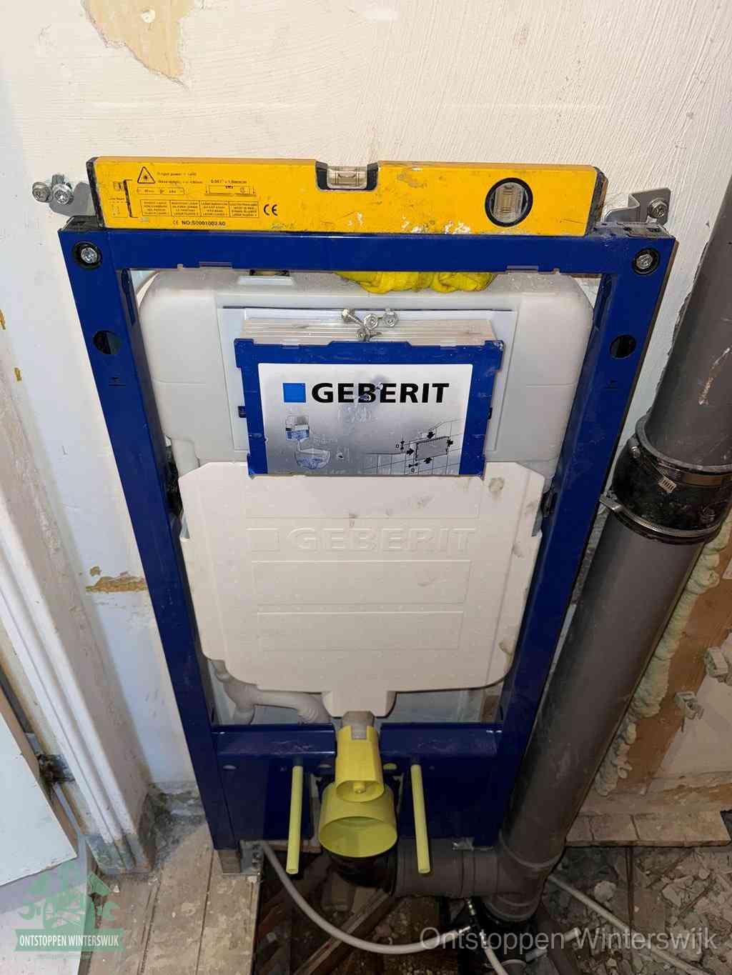 Een Geberit inbouwreservoir met frame voor een hangtoilet tegen de wand, met de afvoerbocht naar de vloer, kenmerkend voor een verstopt hangtoilet in Winterswijk
