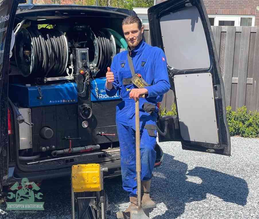 Een monteur bij de werkbus met grote hogedruk-slanghaspels, apparatuur voor hardnekkige afvoerverstoppingen in Winterswijk