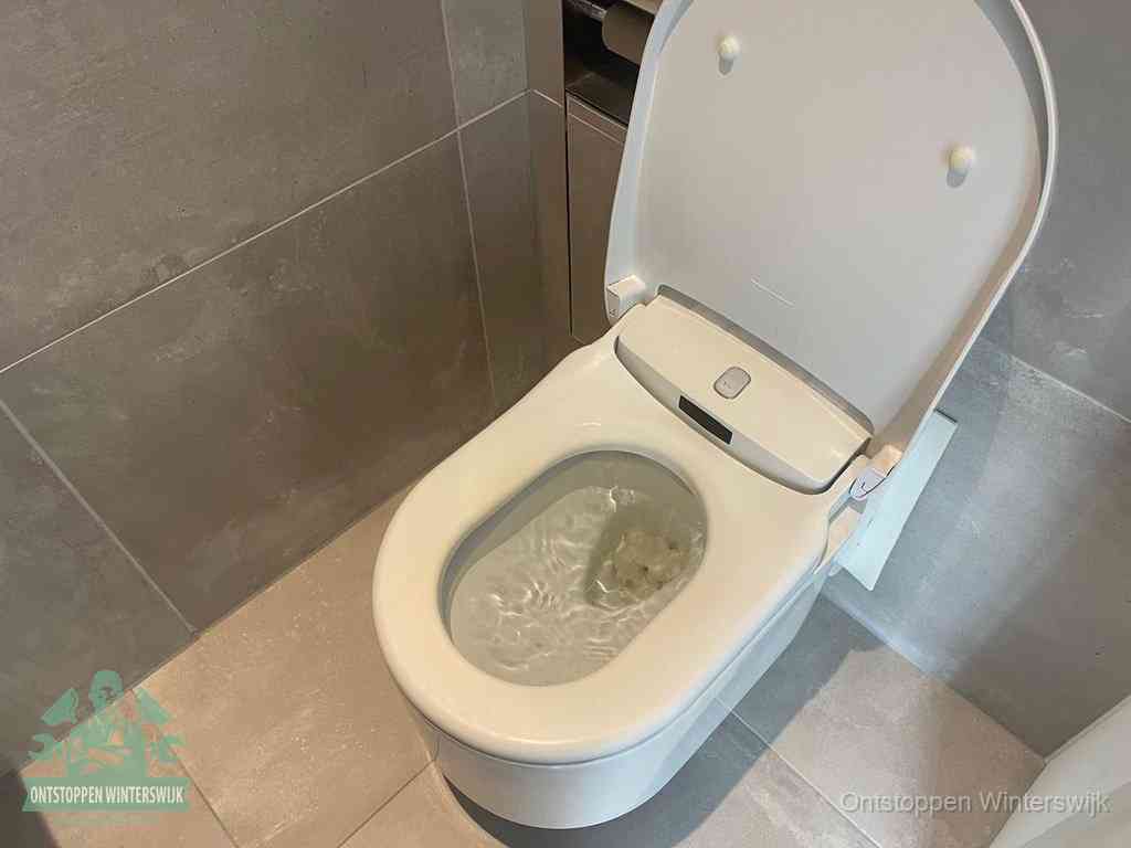 Een toiletpot vol troebel water met drijvend papier en restanten, de meest voorkomende oorzaak van een verstopte wc in Winterswijk