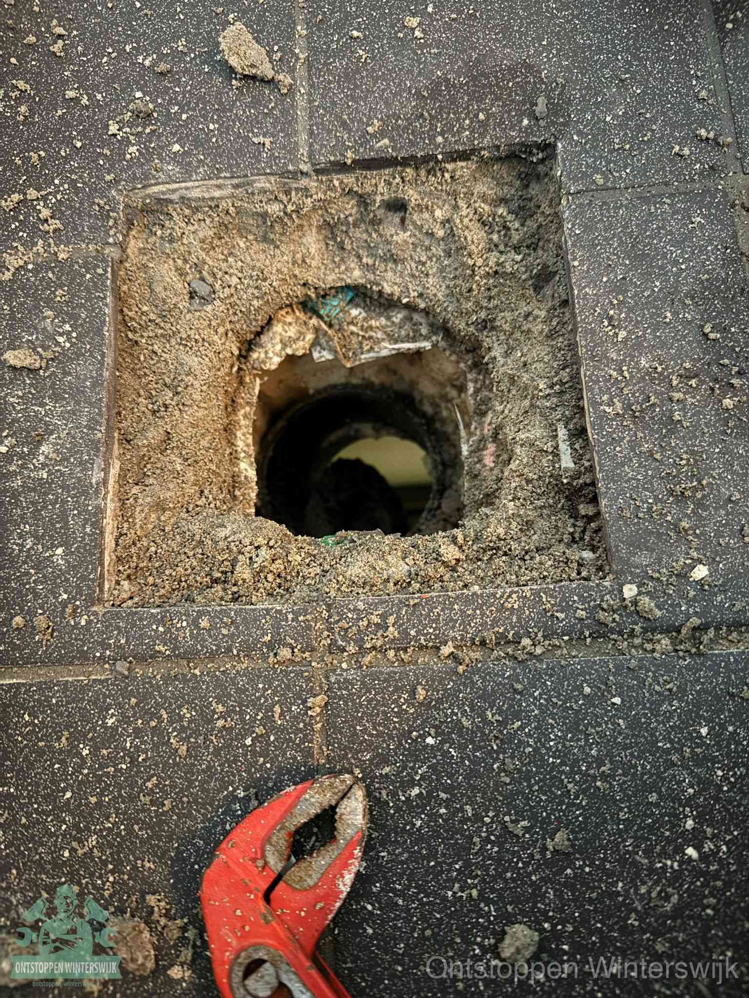 Geopend rioolputje op de erfgrens dat laat zien wie eigenaar is van de riolering in Winterswijk