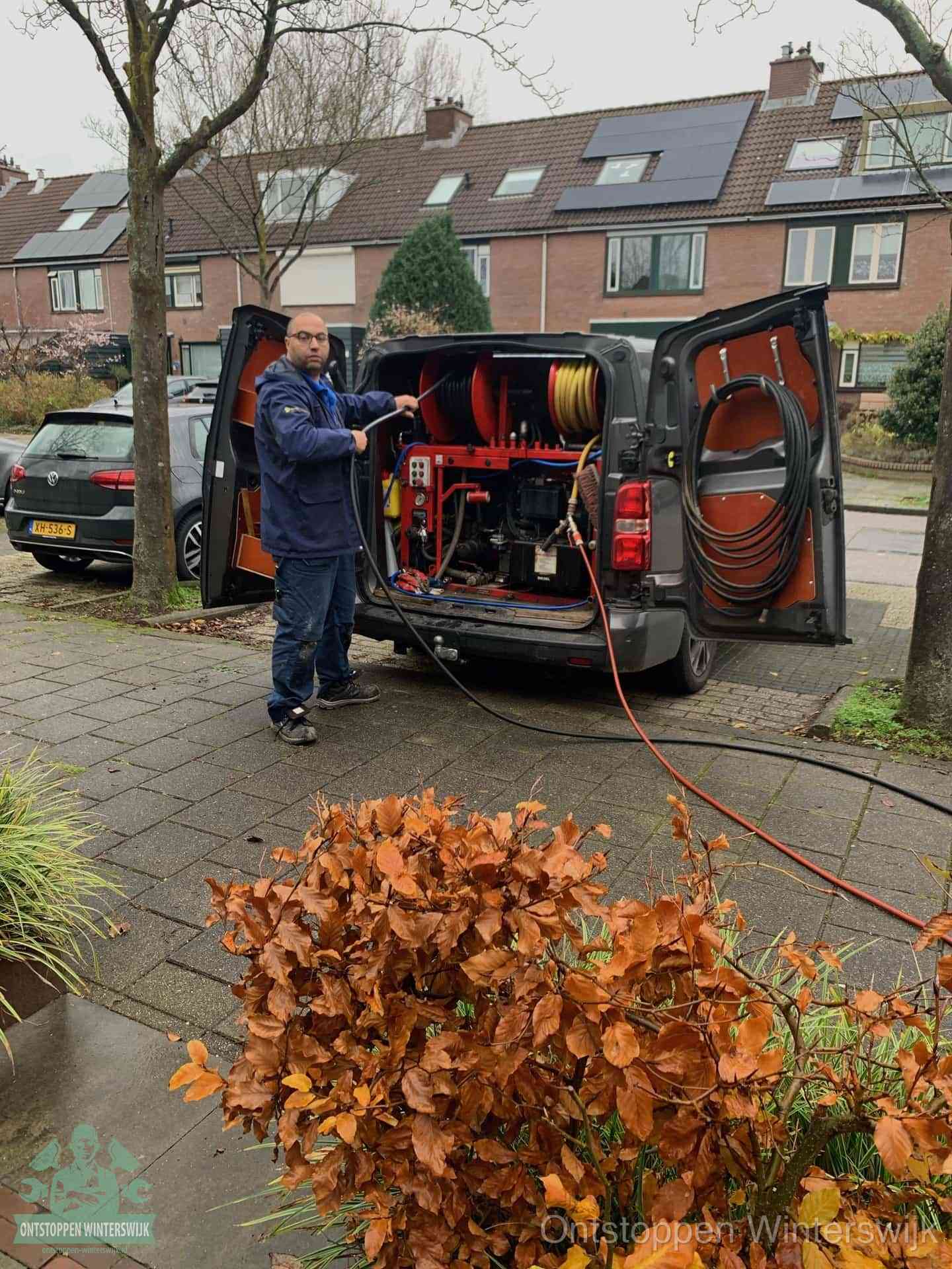 Monteur met rioolreinigingsbus levert rioolservice in de wijk in Winterswijk