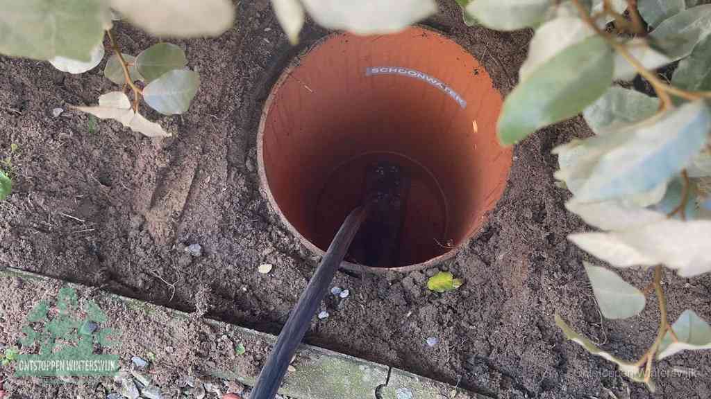 Open inspectieput in de tuin waar een veer rioolvliegjes en stankoverlast aanpakt in Winterswijk