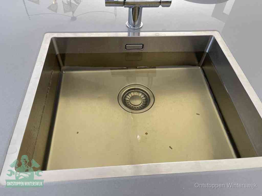 Stilstaand water in een rvs spoelbak dat niet wegloopt, een duidelijk signaal van een gootsteenverstopping in Winterswijk