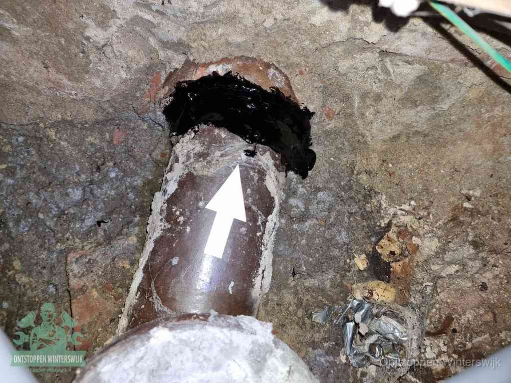 Een oude gres rioolbuis met een beschadigde koppeling onder de vloer, oorzaak van terugkerende structurele wc-problemen in Winterswijk