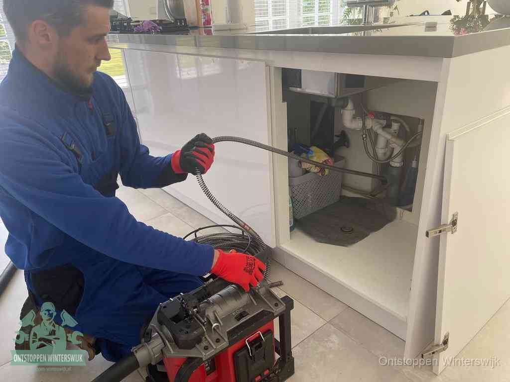Een monteur reinigt de keukenafvoer grondig met een veermachine om terugkerende gootsteenverstoppingen te voorkomen in Winterswijk